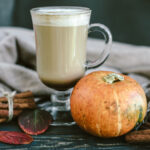 Image of pumpkin spice latte on a wooden board with a sweater